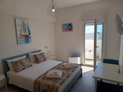 a bedroom with a bed with towels on it at House Salento Central Rooms in Torre San Giovanni Ugento