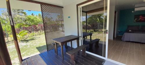 um quarto com uma varanda com uma mesa num deque em Rangi Pearl Lodge em Avatoru