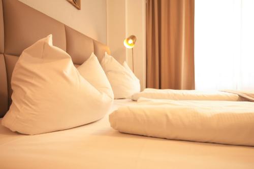 a hotel room with two beds with white pillows at TM Hotel Düsseldorf in Düsseldorf