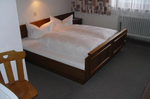 a bedroom with a large bed with white sheets and pillows at Ferienwohnung Reinstadler in Jerzens