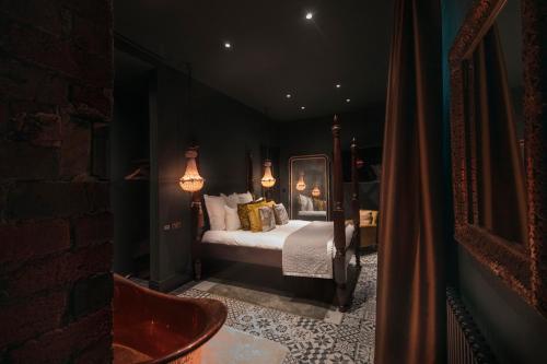 a bedroom with a bed in a dark room at The Bells - Luxury Serviced Apartments in Leeds