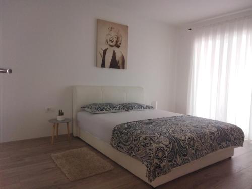 - une chambre avec un lit et une photo sur le mur dans l'établissement Apartmani Biba, à Novi Vinodolski