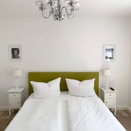 a bedroom with a white bed with a green headboard at Kuckuckswinkel Ferienwohnung Zarah in Schöna