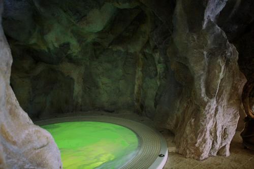 a large green bath tub in a cave at Piz Galin Grand Hotel Family & Wellness in Andalo