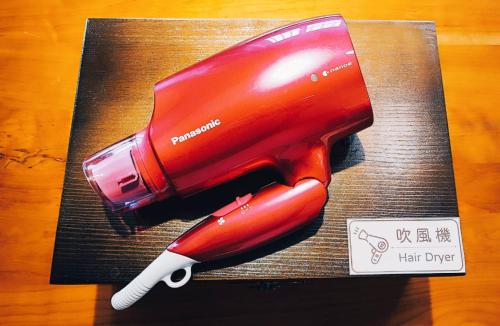 a red hair dryer sitting on top of a table at 安蘭居旅店 An Lan Jie Hotel in Chiayi City