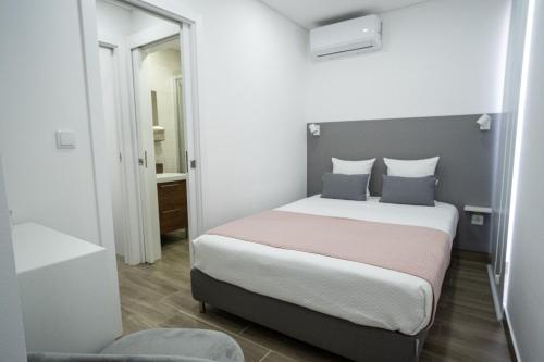 a bedroom with a bed and a mirror at Casas da Barca in Vila Nova de Foz Coa