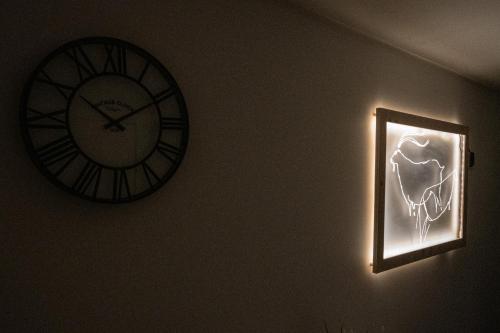 a clock on a wall next to a light with a skull on it at Casas da Barca in Vila Nova de Foz Coa