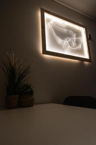 a light on a wall with a picture of a bird on it at Casas da Barca in Vila Nova de Foz Coa