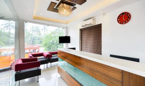 a lobby with a reception desk and chairs and a clock at Itsy Hotels Platinum Inn in Chacka