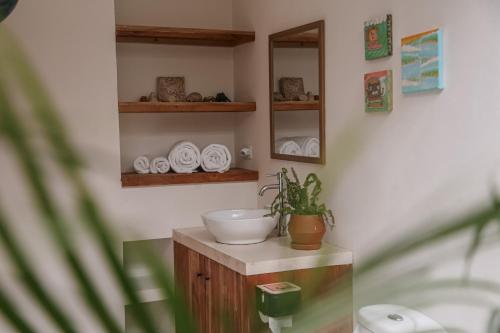 a bathroom with a sink and a mirror at El Hábita CASA MAR in Santa Teresa Beach