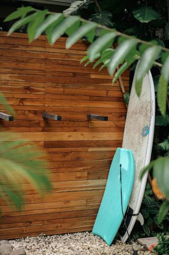 a surfboard leaned up against a wooden fence at El Hábita CASA MAR in Santa Teresa Beach