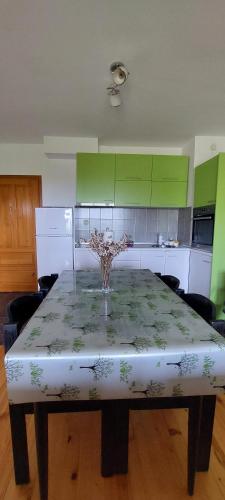 a kitchen with a table with a vase of flowers on it at Villa Ramonda in Dolna Matka
