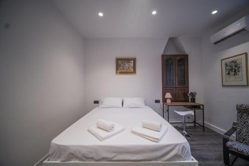 a bedroom with a white bed with two towels on it at Studio Reale Corfu in Corfu