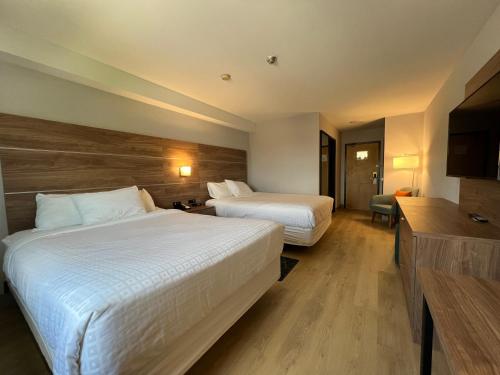 a hotel room with two beds and a television at Super 8 by Wyndham Cornwall ON in Cornwall