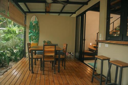 a dining room with a table and chairs on a deck at El Hábita CASA SELVA in Santa Teresa Beach
