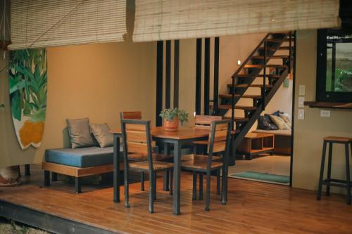 uma sala de jantar com uma mesa e cadeiras e uma escadaria em El Hábita CASA SELVA em Santa Teresa