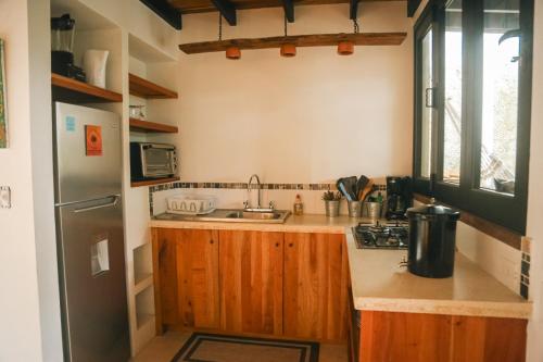 a small kitchen with a sink and a refrigerator at El Hábita CASA SELVA in Santa Teresa Beach