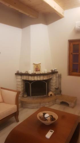 a living room with a fireplace and a table at Vila Thailanda in Katakolo in Pýrgos