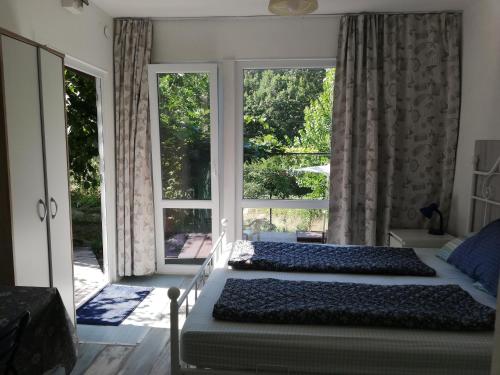 2 letti in una camera da letto con una grande finestra di Summer villa Fani a Sinemorets