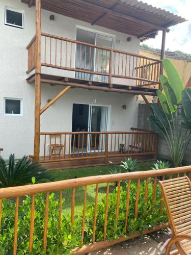 a house with a wooden deck and a balcony at Flat Beira Mar Porto Segur in Porto Seguro