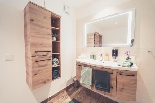een badkamer met een wastafel en een spiegel bij Apartments z‘Haus in St. Gilgen