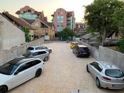 a group of cars parked in a parking lot at Pink House Apartments in Jagodina