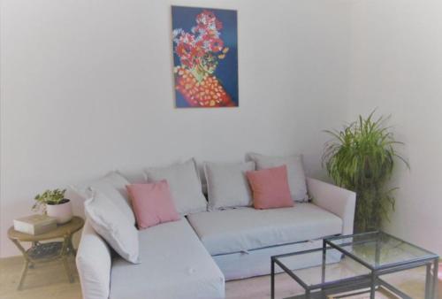 um sofá branco numa sala de estar com um quadro na parede em Le Doubs Vesontio em Besançon