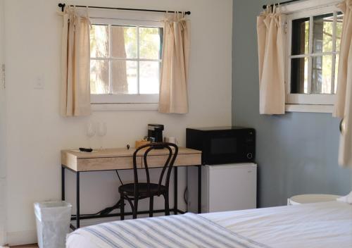 a bedroom with a desk with a television and a bed at Anchor Inn in Traverse City