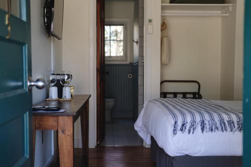a bedroom with a bed and a table and a bathroom at Anchor Inn in Traverse City