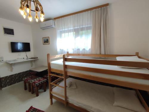 a bedroom with two bunk beds and a television at Sebilhan Apart Hotel in Sarajevo