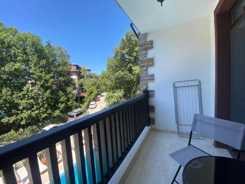 a balcony with a bench and a view of a street at The Green Paradise Apartments in Primorsko