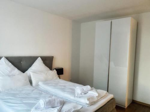 a bedroom with a bed with white sheets and pillows at Cozy Apartment Bernburg 1 in Roschwitz