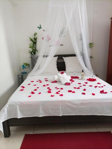 a bedroom with a bed covered in red roses at VILLA AU COEUR DE LA MARMITE in Sainte-Marie