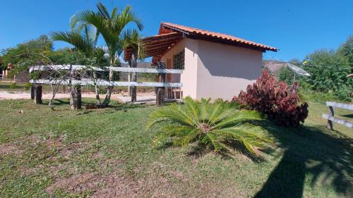 a small house with a fence in a yard at Pousada Portal da Serra in Carrancas