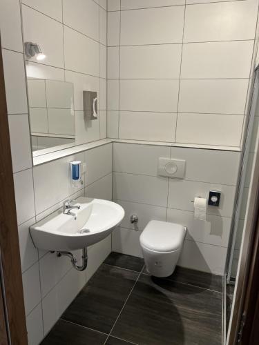 a white bathroom with a toilet and a sink at Hotel Pasa Paradies KOSTENLOSE PARKPLÄTZE in Hanau am Main