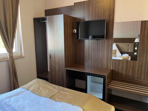 a bedroom with a bed and a tv on a wall at Hotel Pasa Paradies KOSTENLOSE PARKPLÄTZE in Hanau am Main