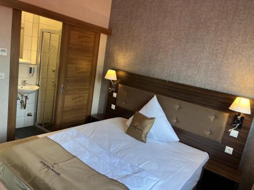 a bedroom with a large white bed and a sink at Hotel Pasa Paradies KOSTENLOSE PARKPLÄTZE in Hanau am Main