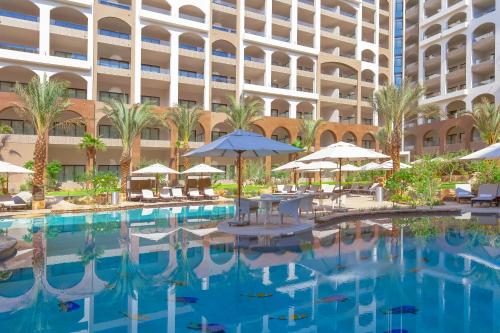 a pool in front of a large building at Villa La Valencia Beach Resort & Spa Los Cabos in San José del Cabo
