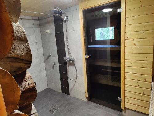 baño con ducha y puerta de cristal en Villa Suopursu, en Karesuvanto