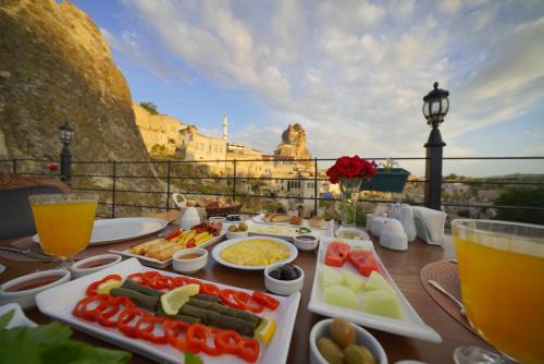un tavolo con cibo e vista sulla città di Serenus Cave Suites a Ortahisar