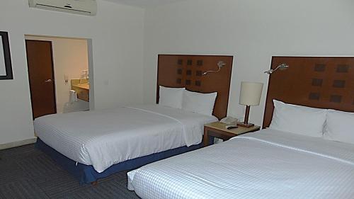 a hotel room with two beds and a lamp at Hotel Ex-Hacienda San Xavier in Guanajuato