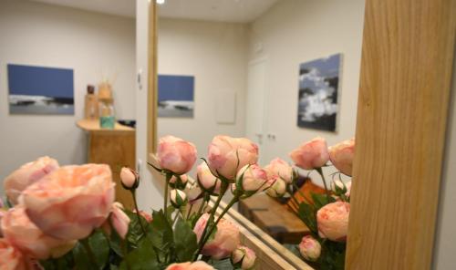 a bunch of pink roses in front of a mirror at Daman Rooms & Breakfast in Barzago