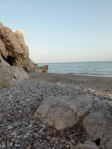 a rocky beach with two large rocks on the shore at Once upon a rock in Pythagoreio