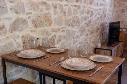 a wooden table with plates and cutlery on it at Once upon a rock in Pythagoreio