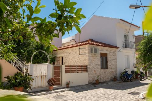 a white house with a gate and a fence at Once upon a rock in Pythagoreio