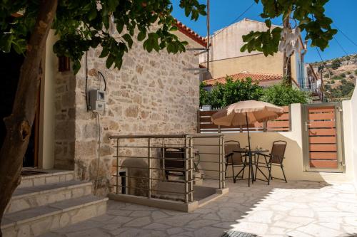 a patio with an umbrella and a table and chairs at Once upon a rock in Pythagoreio