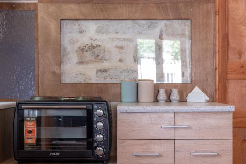 a kitchen with a black microwave and a counter at Once upon a rock in Pythagoreio