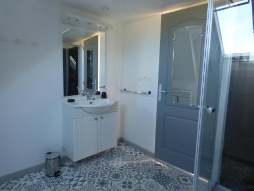 uma casa de banho com um chuveiro, um lavatório e uma porta de chuveiro em gite de kerveg em Bégard