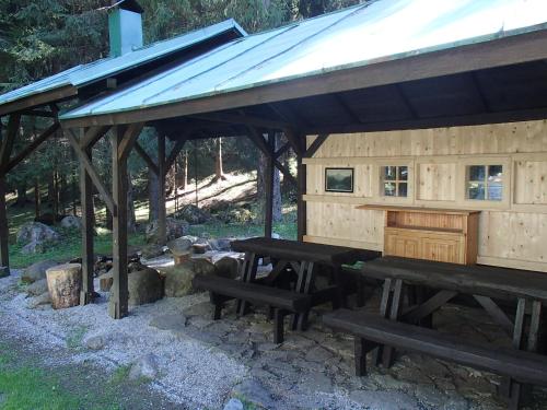a picnic shelter with benches and a piano at Chata Machnatô - Jasná in Demanovska Dolina