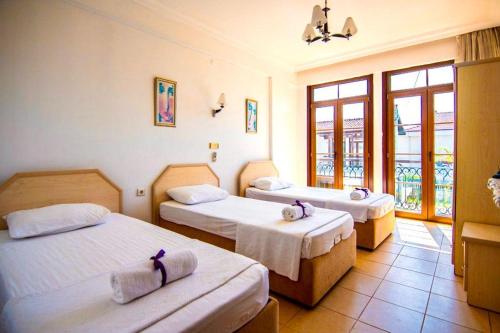 a hotel room with three beds in a room at Villa Mor Fethiye in Fethiye